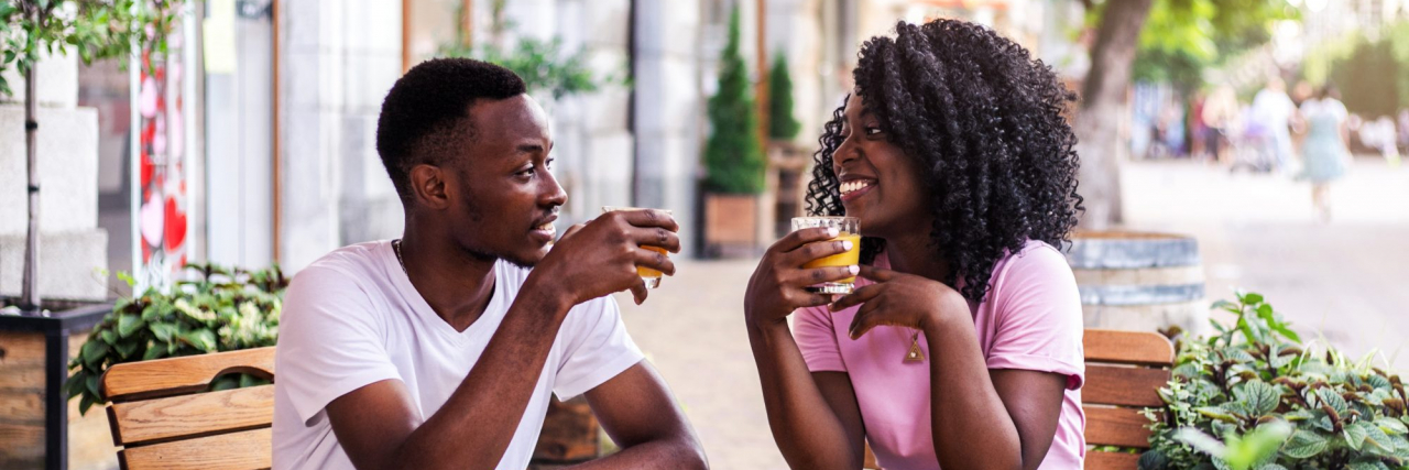 How to Tell Your Date About Your Lupus Portrait of stylish black couple talking to each other at summer street cafe.