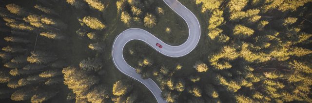 Car driving on winding mountain road. Overhead view..