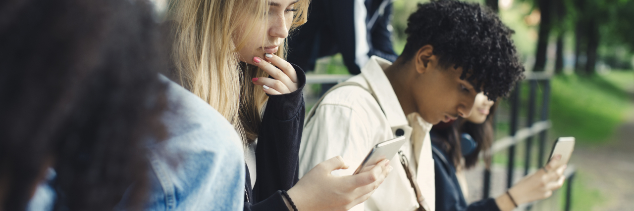 How the Internet's Love for Giving Advice Can Harm People With Anxiety Male and female friends using smart phones in park