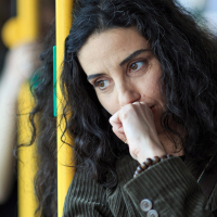 photo of a young woman looking upset or thoughtful on a bus