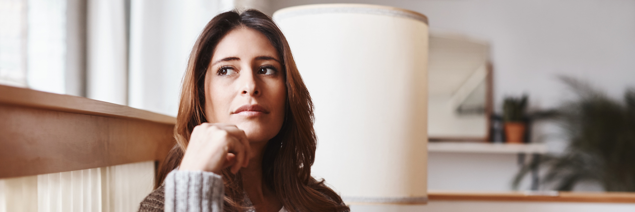 Signs You May Have Silent Celiac Disease Woman sitting in chair thinking.