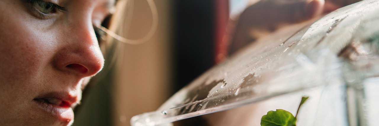Finding Strength in Rebuilding Myself After Trauma Woman looking at seedling in greenhouse