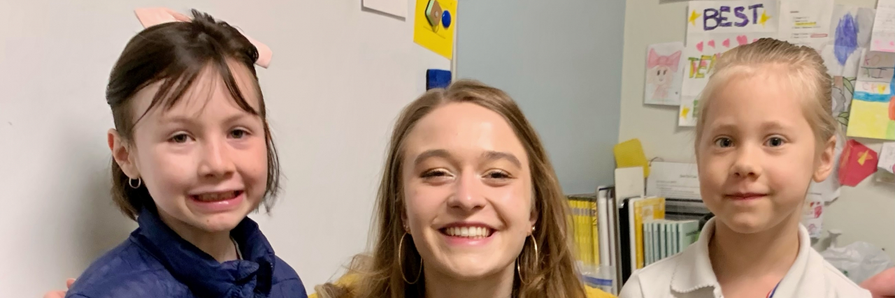 Transitioning Out of Homeschooling My Children With Disabilities The author's children stand with a teacher in a classroom.