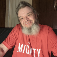 Matthew wearing a red shirt and smiling