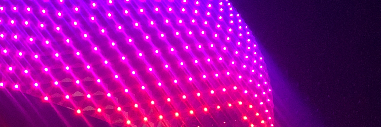 How Disney's New Park Reservation Systems Negatively Impact Neurodivergent Guests EPCOT's spaceship earth at night lit up with LEDs