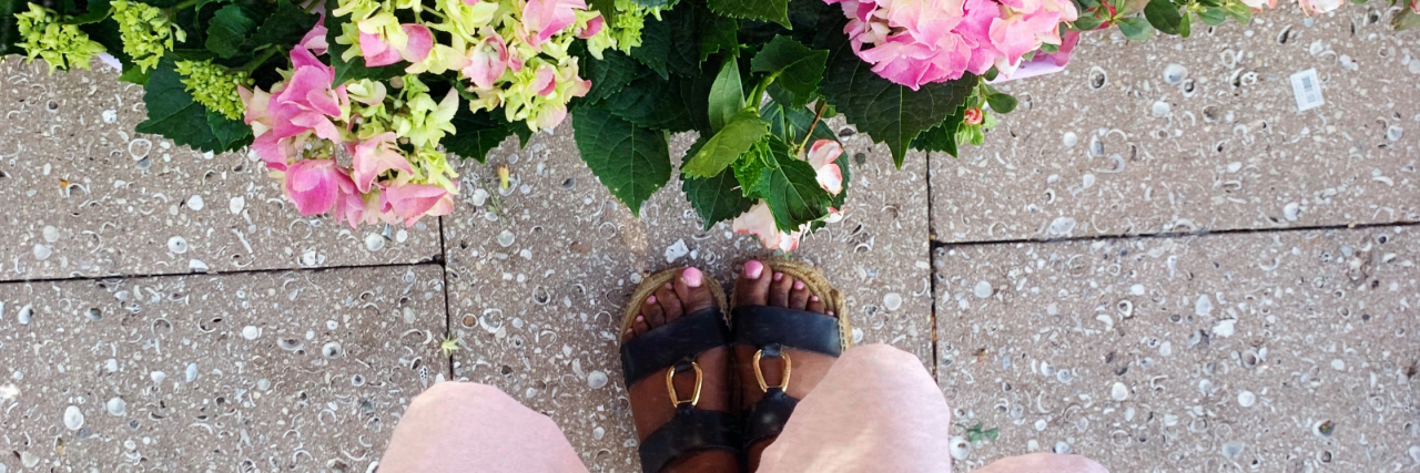 How to Find Joy in Times of Crisis A photo of the bottom of someone's dress, and their open toed shoes. Parallel to them is some pretty pink hydrangeas.