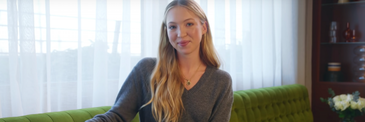 Why Lila Moss Wearing Her Diabetes Tech is a Representation Win Lila Moss sitting on a big couch with a purse smiling at the camera