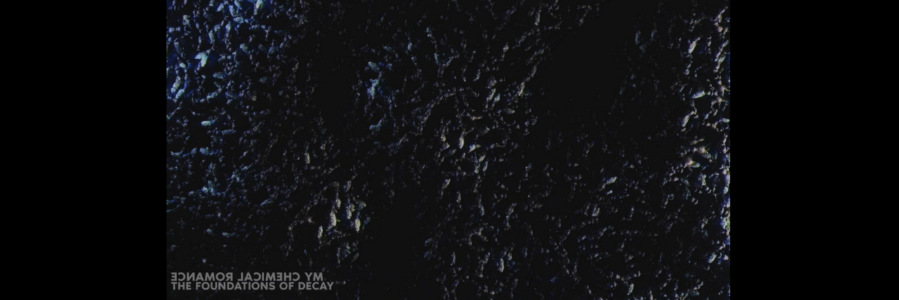 Whether or Not You Need Therapy According to 10 MCR Songs A black static screen with the words "My Chemical Romance" "The Foundations of Decay" on the lower left bottom.