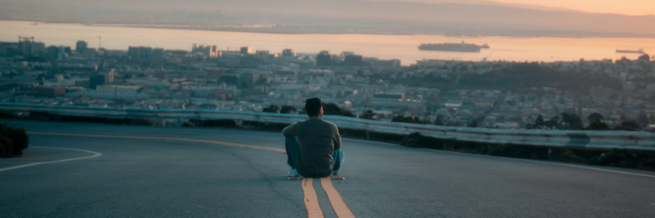The Will to Want an Extraordinary Life With Anxiety and Depression Man sitting on road watching sunset