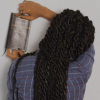 Black woman with braids, facing away from the camera holding a journal or book