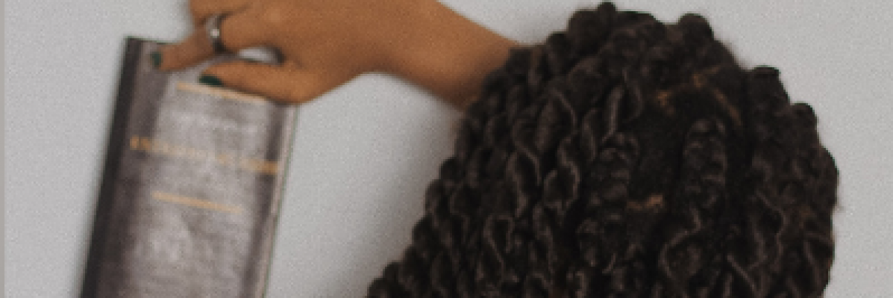 Writing About Sexual Abuse as a Ghost in My Fiction and Poetry Black woman with braids, facing away from the camera holding a journal or book