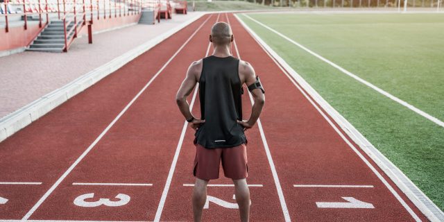 I Loved Running — and Now I Won't Run From My Multiple Sclerosis A man of color stands on the track with his hands on his hips.