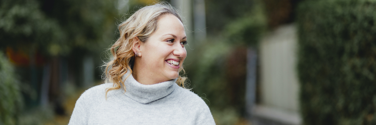 Bringing Humanity Into the Reality of Chronic Pain Care Portrait of woman on city street with trees behind her, looking to the side