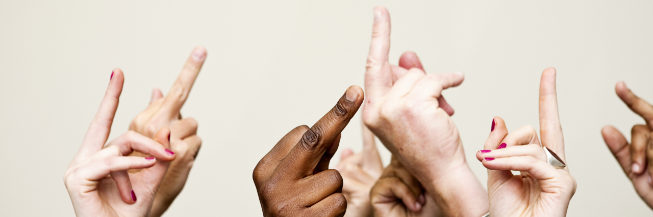 If You Struggle With Your Mental Health, Being 'Negative' May Help You A bunch of hands giving the middle finger