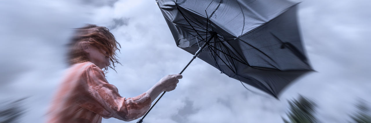 It's OK to Be Angry About How IBD Has Changed Your Life Woman fighting rainstorm.