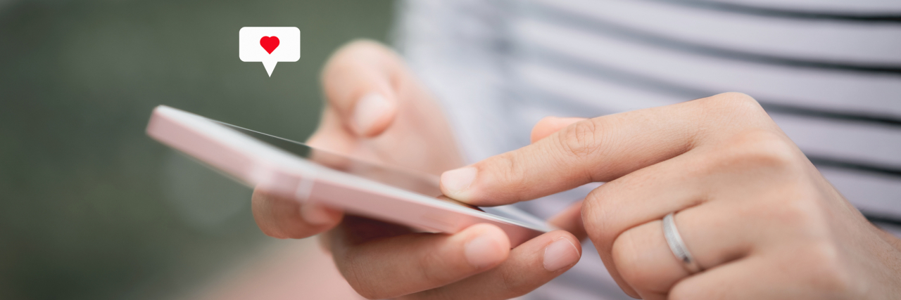 10 Tips for the Person With Anxiety Who Wants to Use a Dating App Close up woman hand using phone with a heart icon