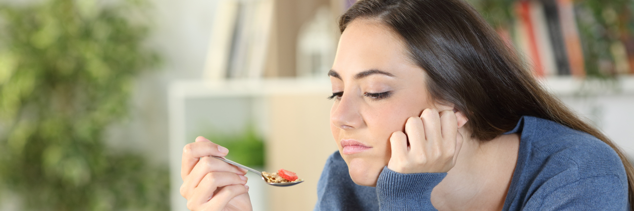 12 Tips for When Food Makes You Nauseous Woman with nausea trying to eat.