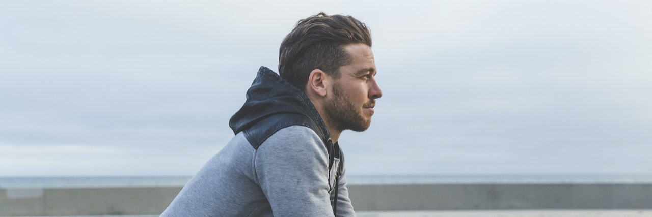 What It's Like to Be 'Other'  Man leaning on wall looking out to sea
