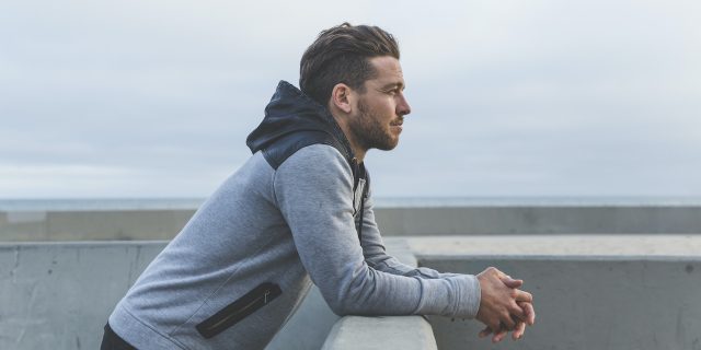 What It's Like to Be 'Other'  Man leaning on wall looking out to sea