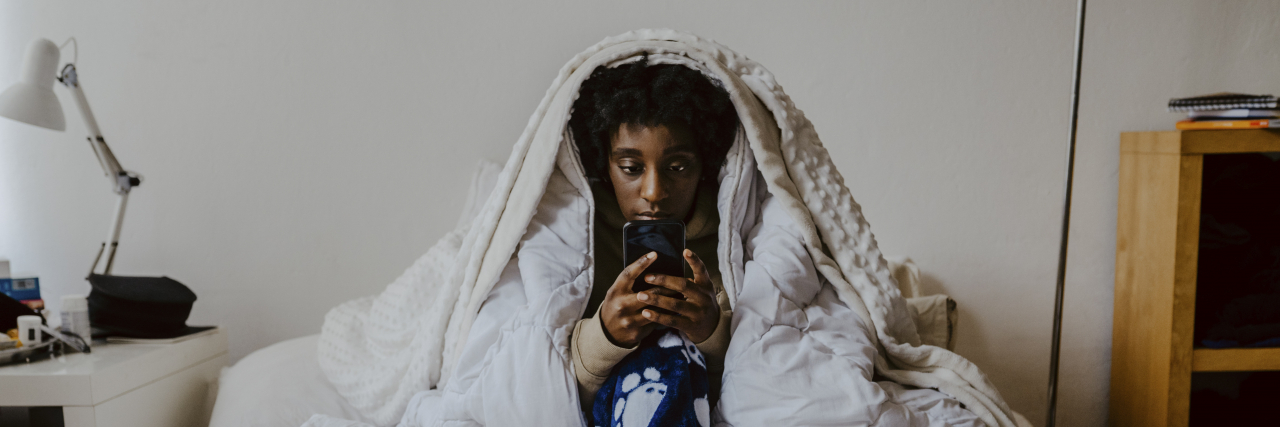 Affirmations for People Who Get Anxiety Taking a Sick Day From Work Young woman using smart phone while sitting in bedroom