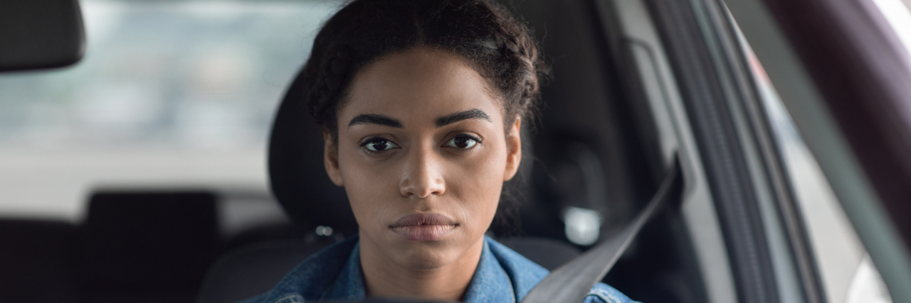 What Happened When One Woman Stopped Being a 'Strong Black Woman' A black woman holding a steering wheel staring intently ahead of her