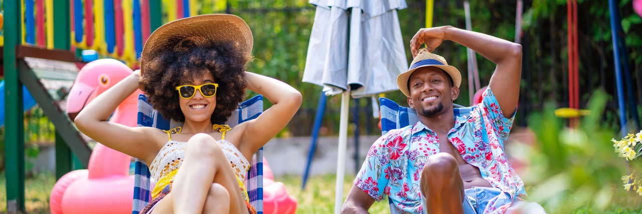 5 Amazing Staycation Planning Tips to Rejuvenate Your Mental Health Couple sitting on lounge chairs in the back yard and having sunbath during their staycation.