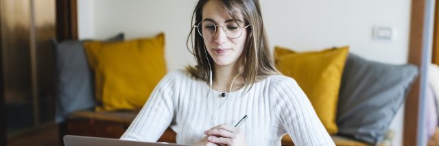 Woman studying at home with laptop and headphones