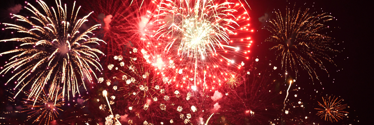 Sensory Overload -- Why I Hate the 4th of July as an Autistic Person Red fireworks in the sky.