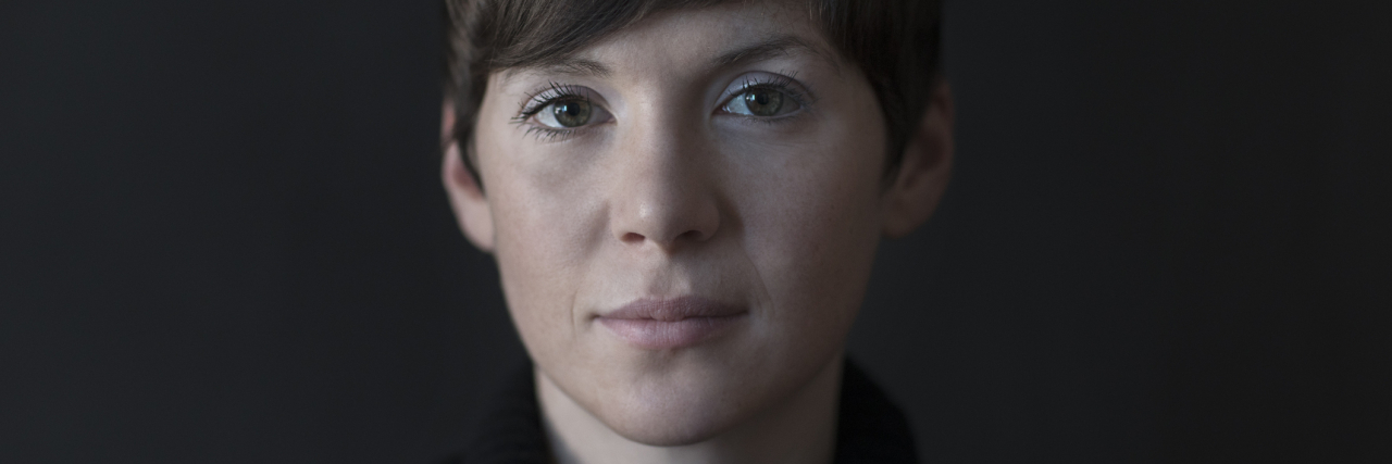 What to Do When Someone Doesn't Believe Your BPD Is Real photo of a woman with a serious expression looking into the camera