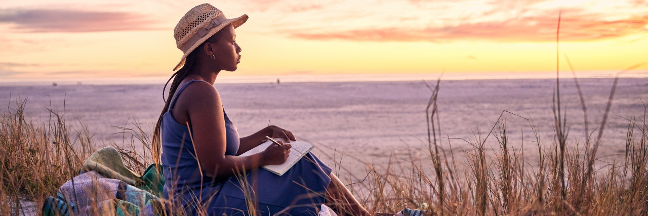 Incorporating Grief Into Your Day-to-Day Life Shot of a young woman writing in her journal at the beach