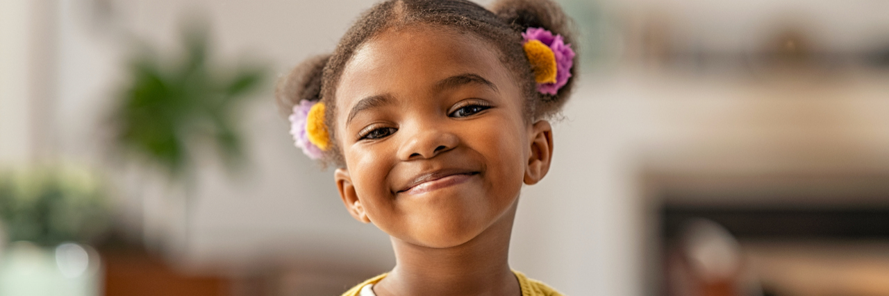 Help Children Learn Healthy Boundaries by Not Forcing Them to Hug Young Black girl smiling and with her hair in pig tails