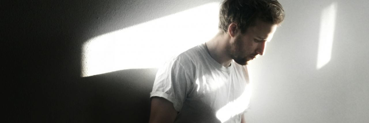 Growing Up Feeling Unable to Let Go of Guilt From Childhood photo of a man leaning against a wall