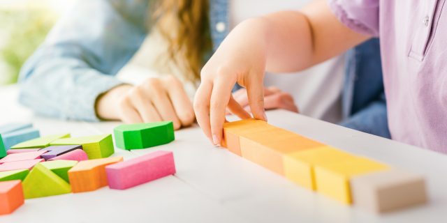 Parents, It's OK to Need In-Home Help for Your Autistic Child Child playing with wood blocks