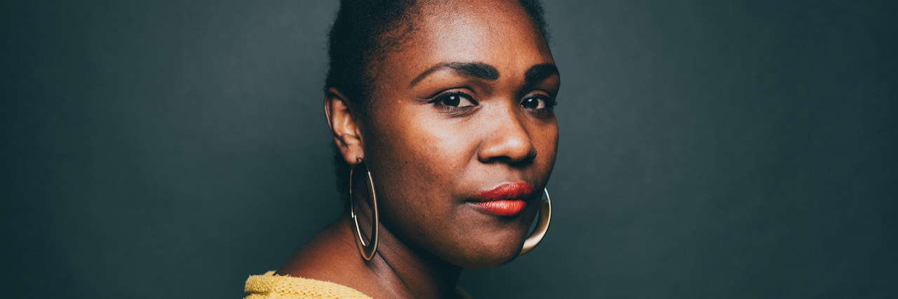 Letter to Birth Moms After the Supreme Court Overturned Roe v. Wade A Black woman wearing a yellow sweater, hoop earrings and red lipstick. Her hair is pulled back.