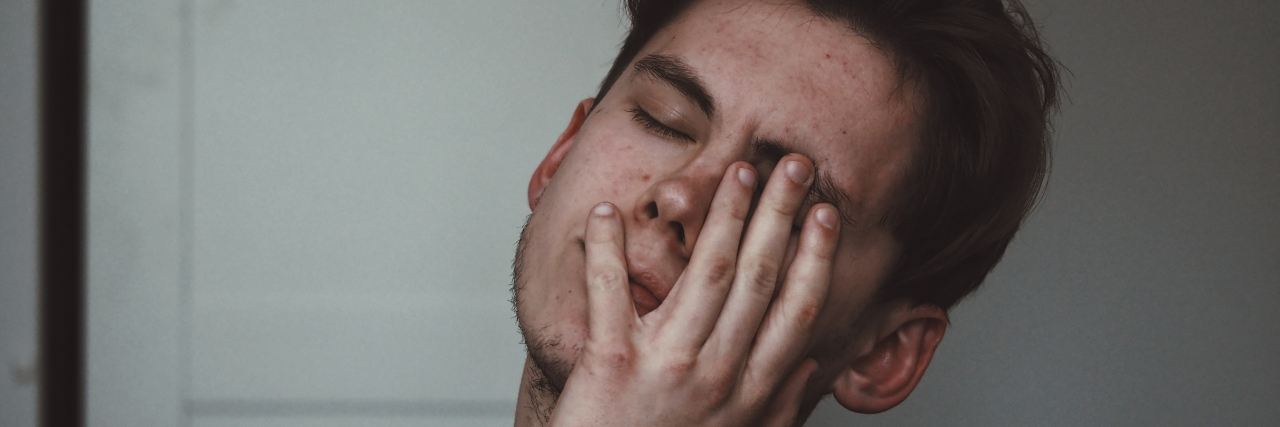 I'm Fine, and Other Lies I've Told Myself in Life With Chronic Illness Tired man resting his face in his hand