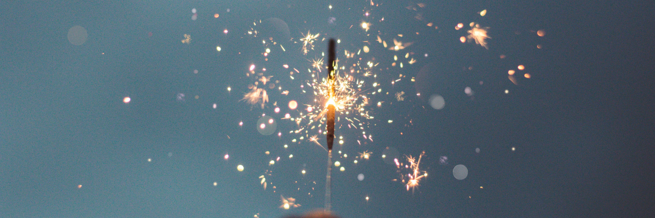 What Seeking Independence Looks Like on My Chronic Illness Journey Photo of a hand holding a sparkler
