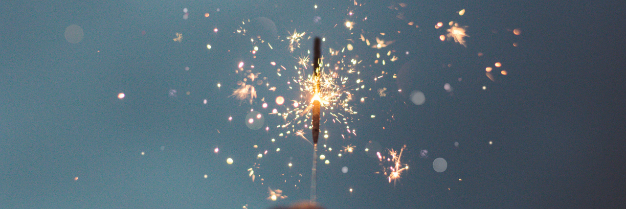 Photo of a hand holding a sparkler