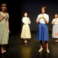 The author stands on stage with the cast of a musical.