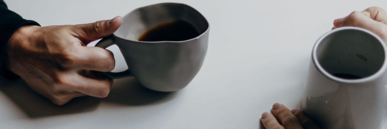 I Can Still Have a 'Normal' Range of Human Emotions With Bipolar Disorder Photo of two people's hands holding mugs on a table