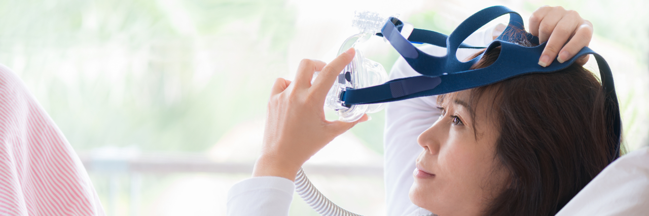 Can Sleep Apnea Affect Your Mental Health? Woman putting on CPAP machine