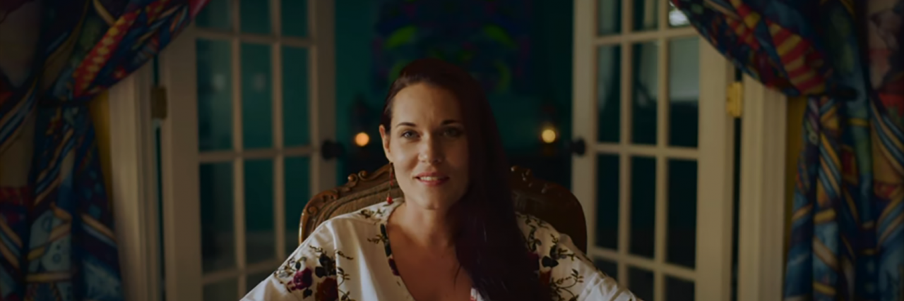 'The Deep End': Why Teal Swan's Cult of Personality Is Dangerous to Trauma Survivors Teal Swan sitting in a room, smiling at the camera, with doors open behind her.