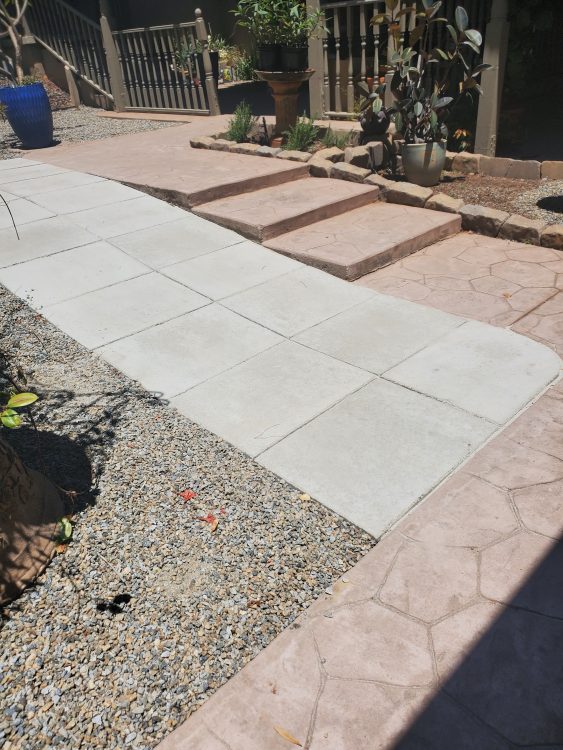 A tiled walkway leading up to a house with shallow steps on one side.