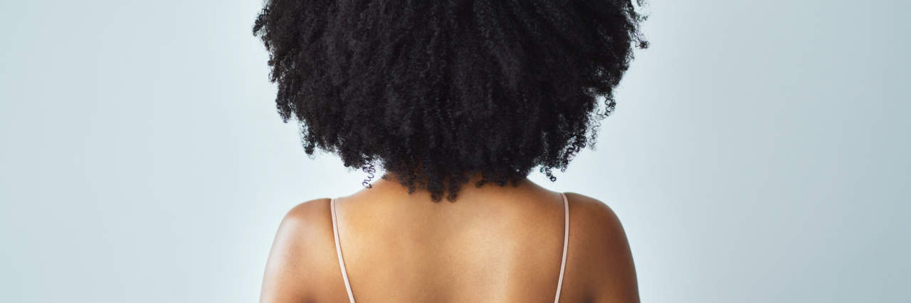 4 Natural Hair Maintenance Hacks for Black People With ADHD Rearview studio shot of a young woman with curly hair