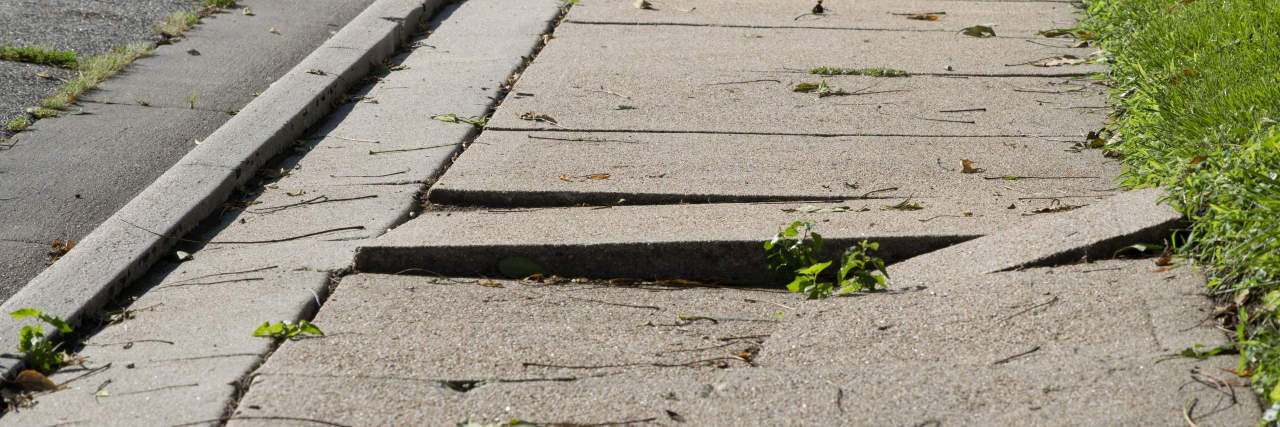 The Everyday Obstacles I Encounter as a Wheelchair User Uneven damaged sidewalk, tripping hazard.
