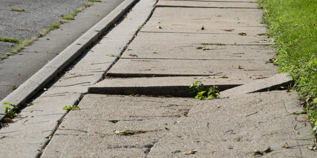 The Everyday Obstacles I Encounter as a Wheelchair User Uneven damaged sidewalk, tripping hazard.