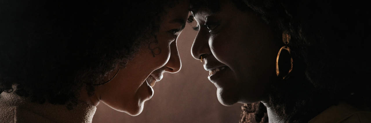 How Rom-Coms Can be a Healing Tool After Abusive Relationships Two Black women caressing and loving on one another. Their foreheads are pressed together and they're staring longingly in one another's eyes.
