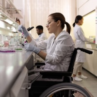 Side view of female lab worker in wheelchair