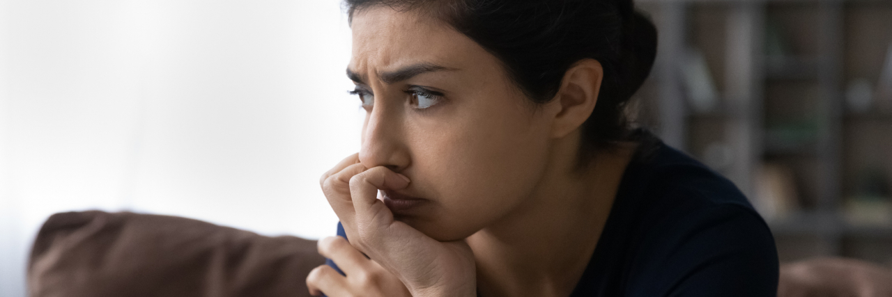 How I Wish Health Provider Would React to Seeing 'Anxiety' in My Chart photo of a young person resting their chin on their hand, looking out window, lost in thought or concern