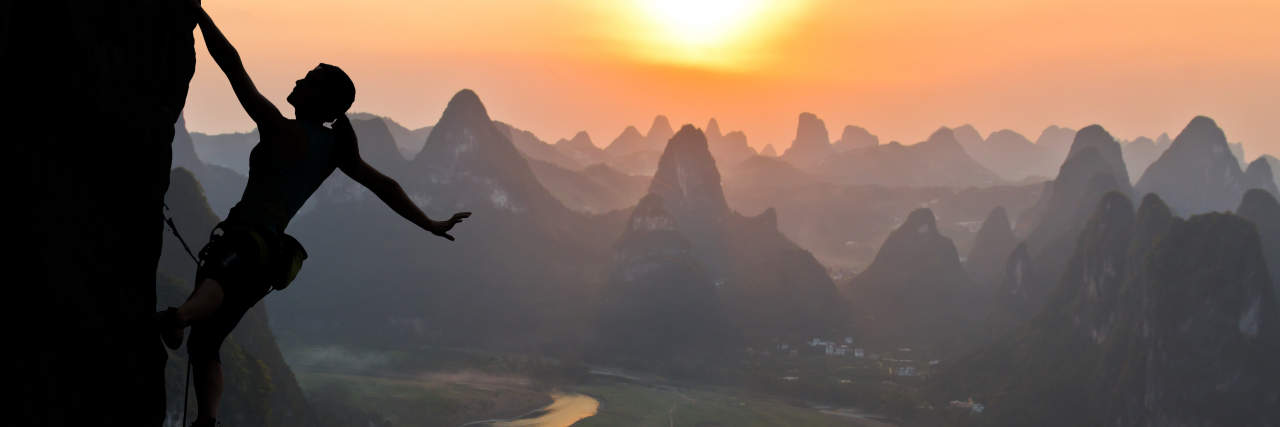 The Mountains We Climb in Life With Chronic Illness Silhouette of female climbing mountain.