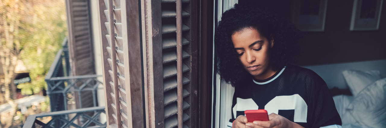 How a Digital Nomad Lifestyle Can Harm Your Mental Health Depressed woman at home text messaging